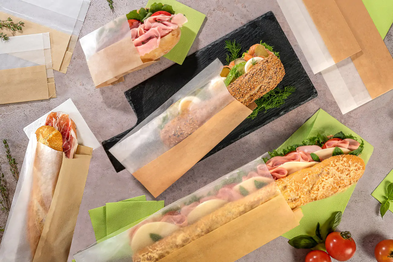 Belegte Baguettes in Papiertüten liegen auf einem Tisch
