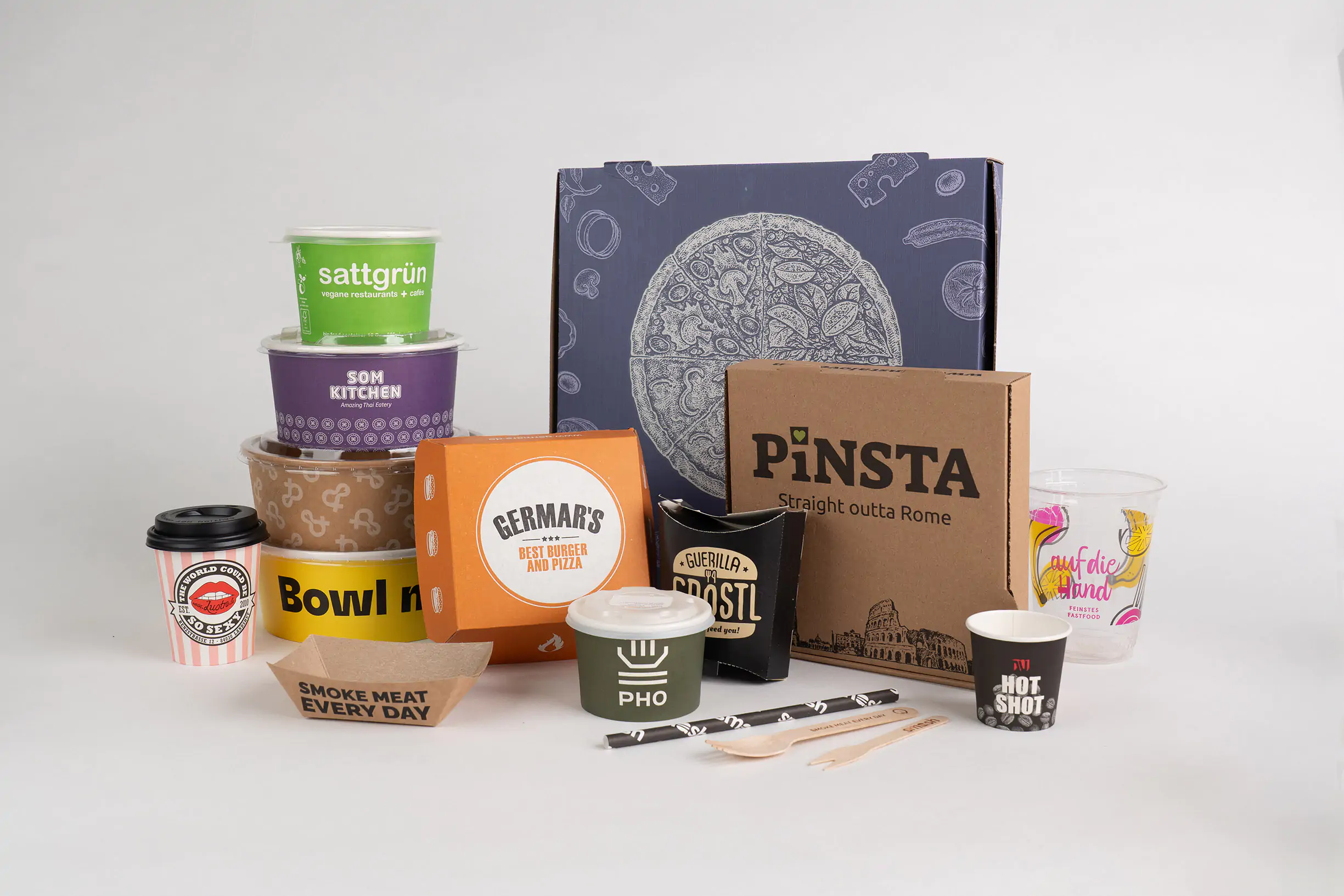 Vor einem weißen Hintergrund stehen verschiedene To-go-Verpackungen mit individuellem Branding