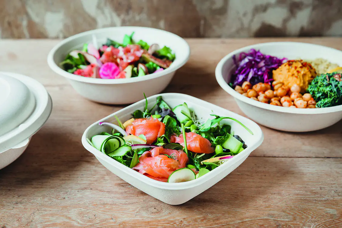 Auf einem Holztisch steht eine Be-Pulp-Salatschale aus Bagasse, gefüllt mit Salat
