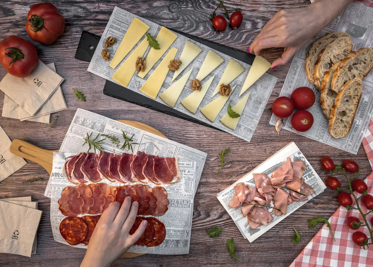 Metzgerei-Einschlagpapier auf einem Holztisch mit Wurst und Käse