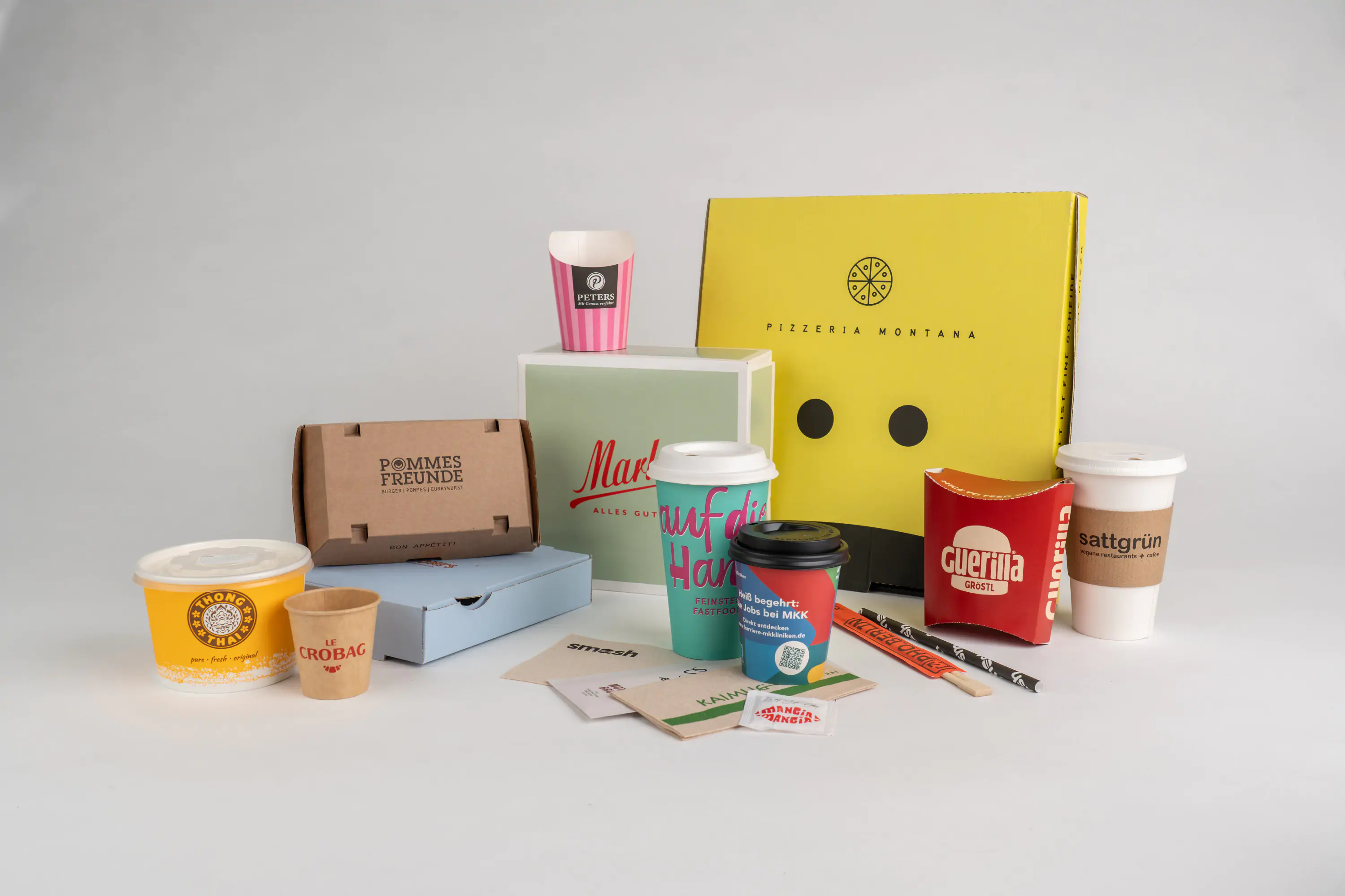 Vor einem weißen Hintergrund stehen verschiedene Verpackungen mit individuellem Branding