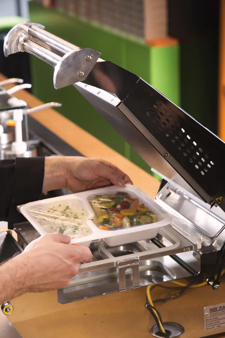 Die Pappschale mit Salat ist mit einer Siegelfolie verschlossen