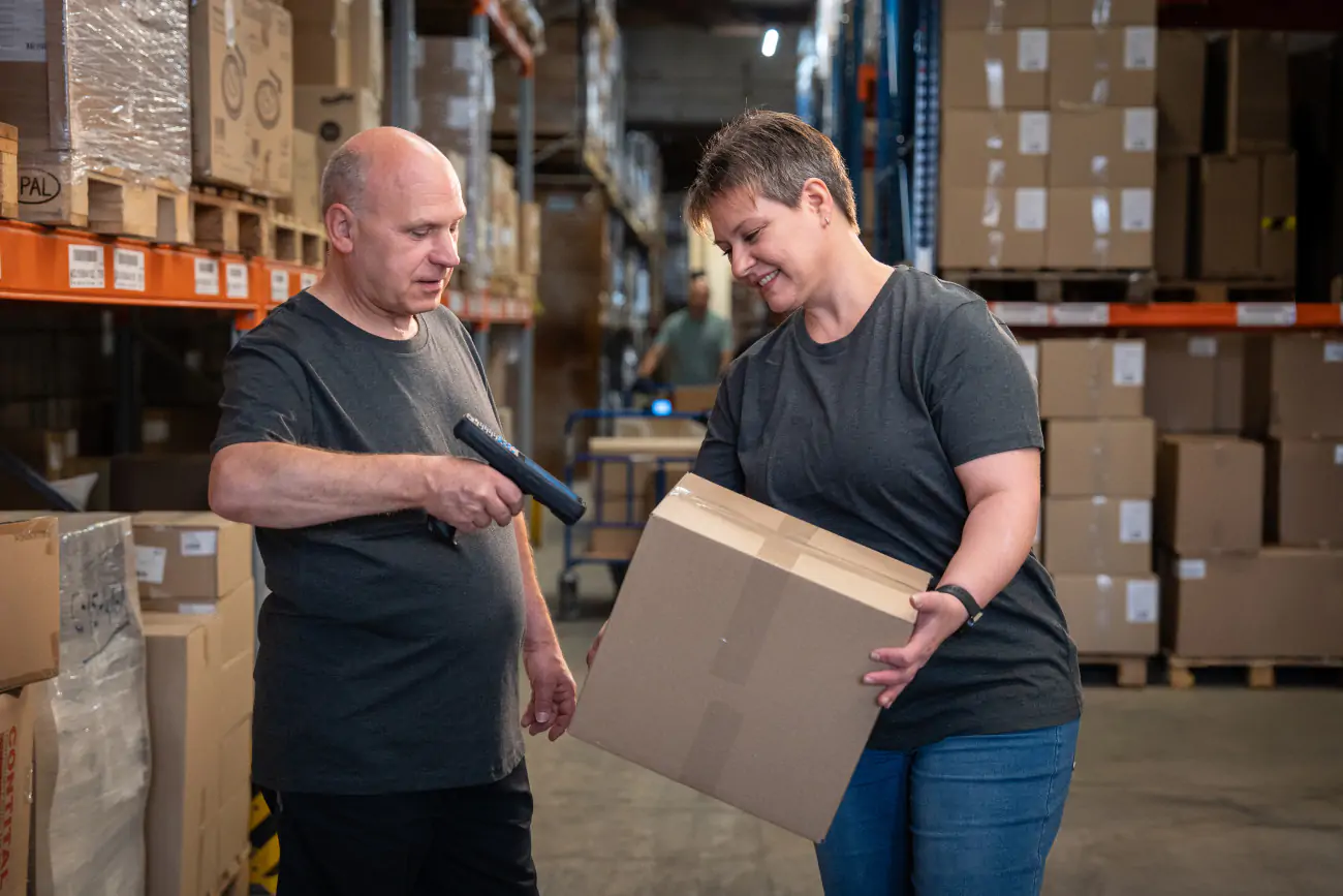 Logistik & Versand, Mitarbeiter im Lager scannt ein Paket