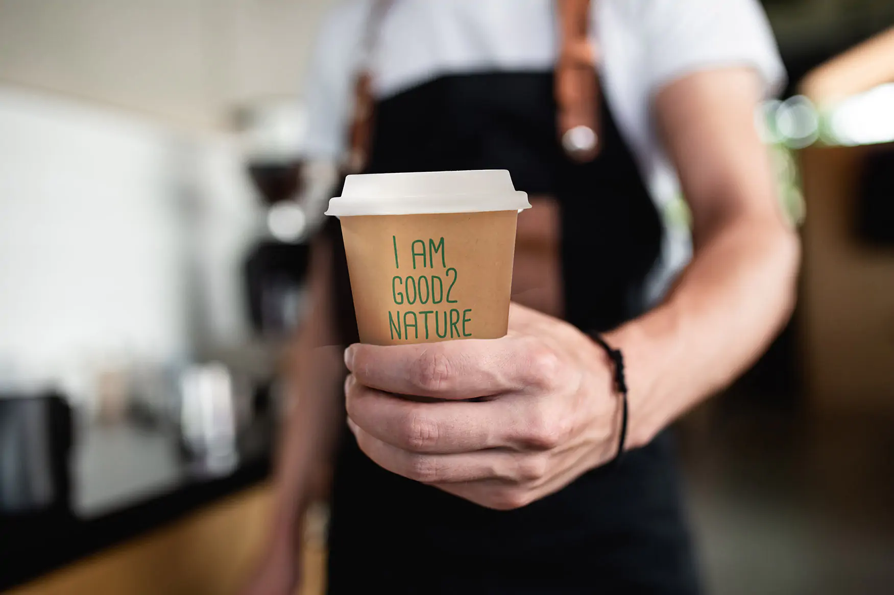 Close up von einem Togo Kaffeebecher aus Pappe in einer Hand  